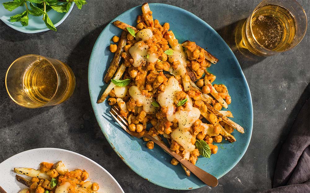 Chickpea Masala Poutine with baked fries and squeaky cheese curds,
