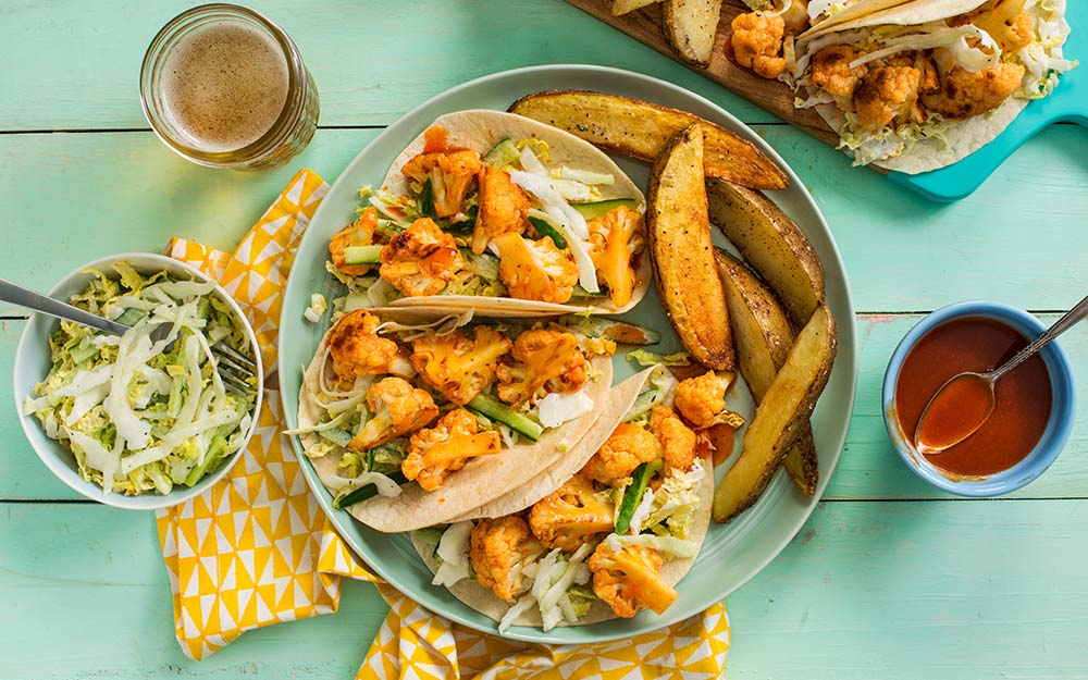 Honey Buffalo Cauliflower Tacos with roasted potato wedges and crunchy ranch salad,